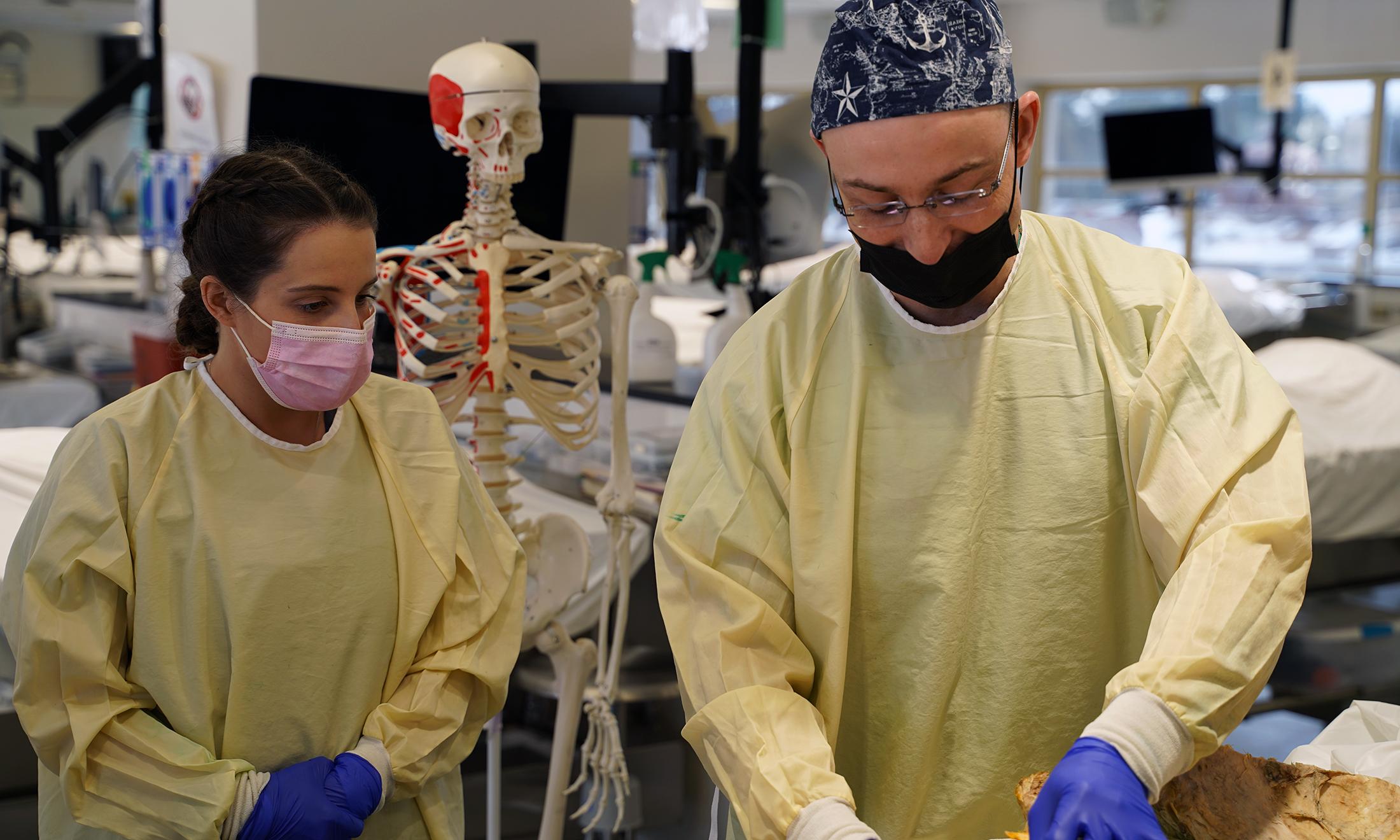 An image of a surgeon teaching a student in OUWB's anatomy lab.