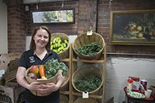 image of Jennifer Lucarelli holding a basket of fruits and vegetables in a market